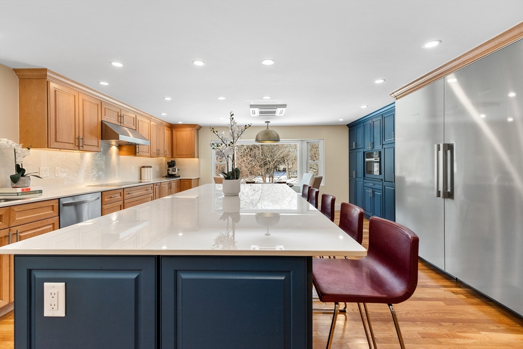 1 Maureen Road Lexington, MA 02420 - Photo 18 of 40 a large kitchen with stainless steel appliances kitchen island granite countertop a table and chairs in it