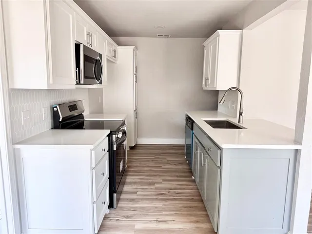 a kitchen that has a sink and a stove in it