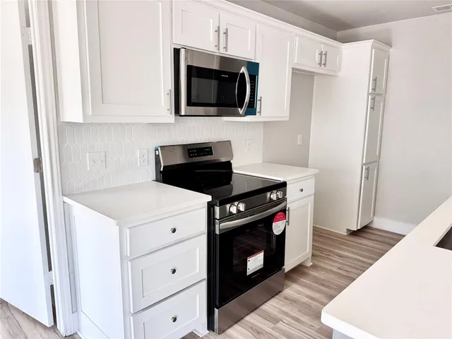 a kitchen with stainless steel appliances a stove a microwave and cabinets