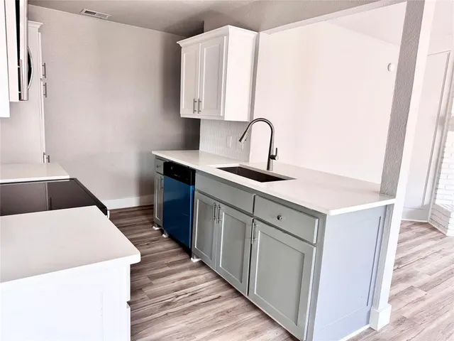 a kitchen with a sink a stove and cabinets