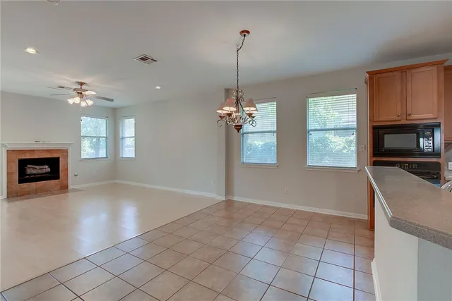 a view of a livingroom with a chandelier fireplace and windows