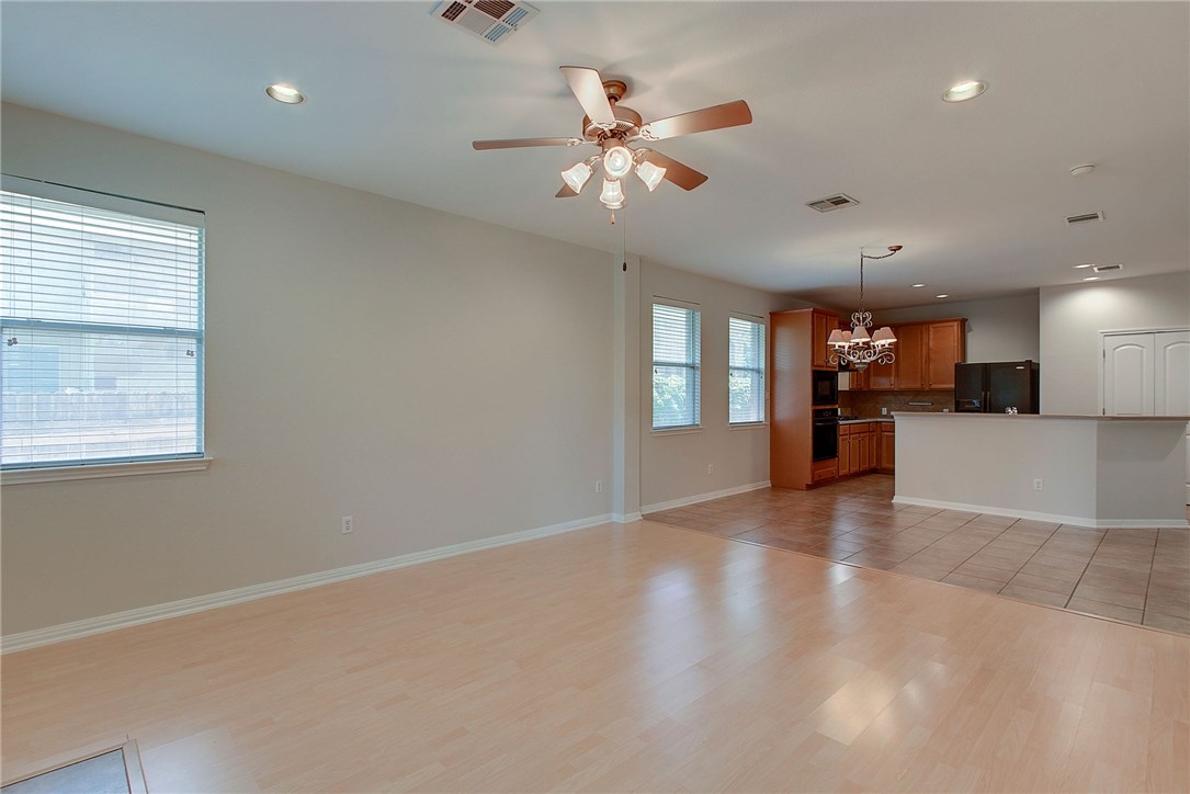 2993 Freemont Street Round Rock, TX 78681 - Photo 13 of 32 an empty room with windows and chandelier fan