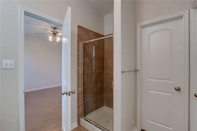 a bathroom with a shower and a glass door