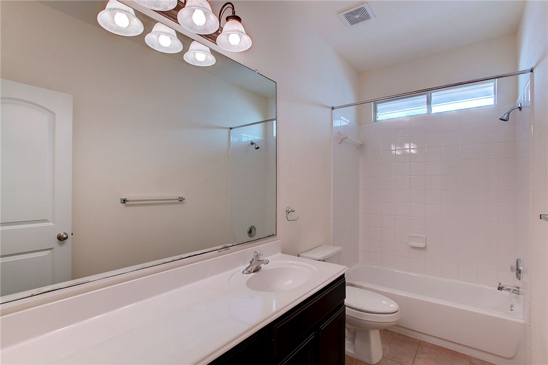 2993 Freemont Street Round Rock, TX 78681 - Photo 27 of 32 a bathroom with a sink a toilet and shower