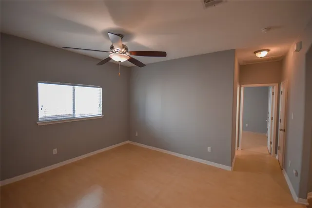 en empty room with windows and fan