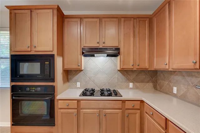 a kitchen with granite countertop white cabinets and stainless steel appliances