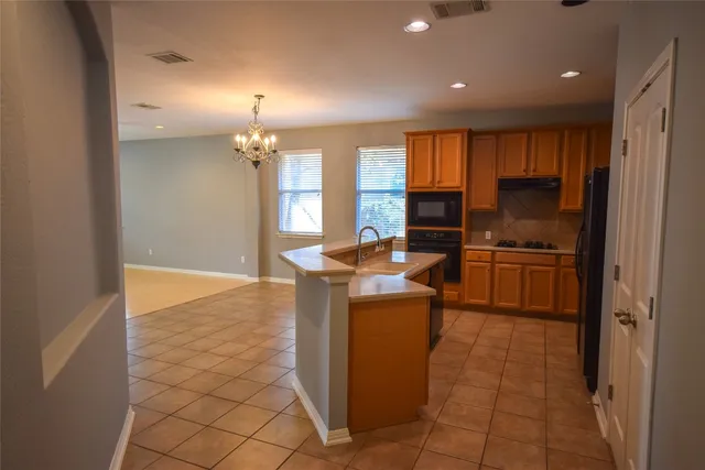 a kitchen with stainless steel appliances granite countertop a refrigerator and a stove top oven