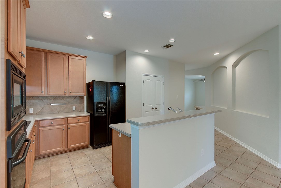 2993 Freemont Street Round Rock, TX 78681 - Photo 7 of 32 a kitchen with a sink and refrigerator