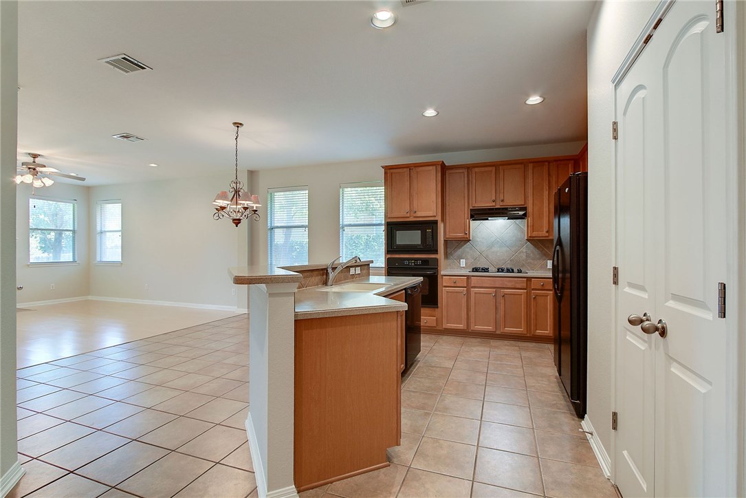2993 Freemont Street Round Rock, TX 78681 - Photo 8 of 32 a kitchen with stainless steel appliances granite countertop a sink and cabinets