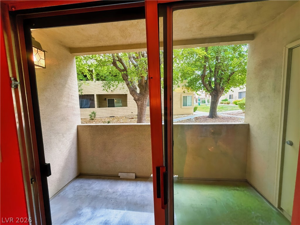 1852 North Decatur Boulevard, Unit 101 Las Vegas, NV 89108 - Photo 24 of 45 Sliding glass doors open directly to a private covered patio overlooking mature green trees.