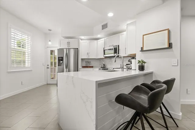 a kitchen with stainless steel appliances cabinets a sink and a refrigerator