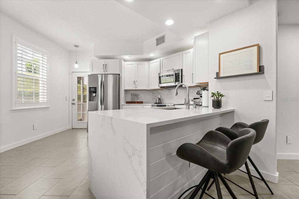 a kitchen with stainless steel appliances cabinets a sink and a refrigerator