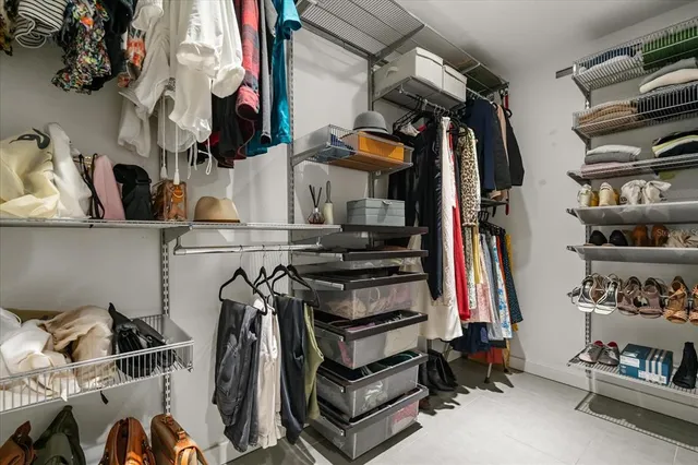 a view of walk in closet with clothes and shoes