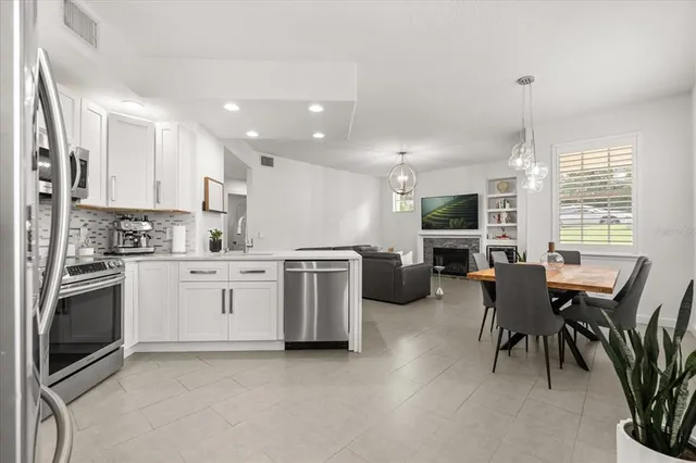a kitchen with a table chairs microwave and cabinets