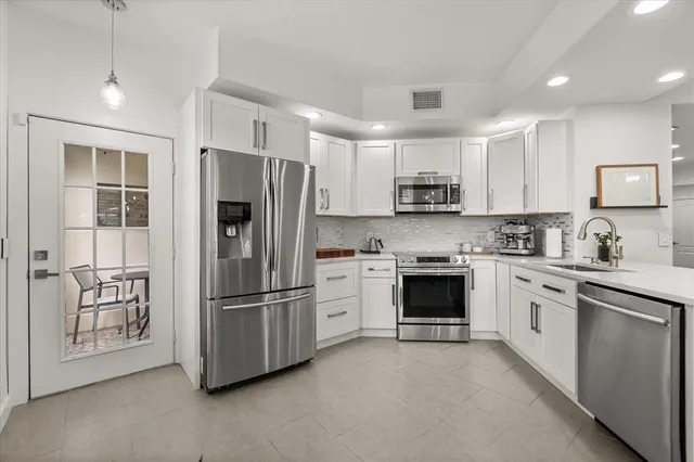 a kitchen with stainless steel appliances granite countertop a refrigerator and a stove top oven