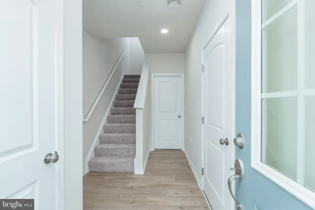 a view of a hallway with wooden floor and entryway