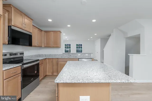 a large kitchen with granite countertop a sink and stainless steel appliances