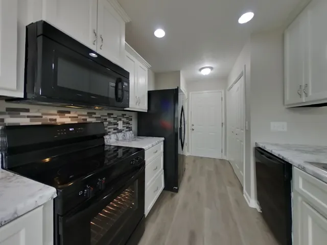 a kitchen with stainless steel appliances granite countertop a stove a refrigerator and a microwave