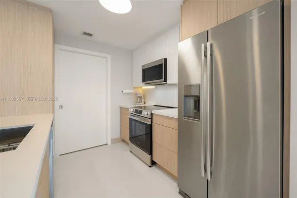 a kitchen with stainless steel appliances a refrigerator and a stove top oven