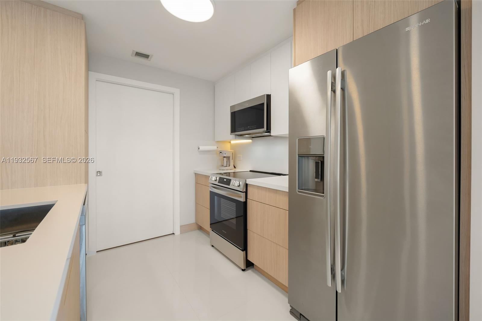 600 Northeast 27th Street, Unit 2401 Miami, FL 33137 - Photo 12 of 52 a kitchen with stainless steel appliances a refrigerator and a stove top oven