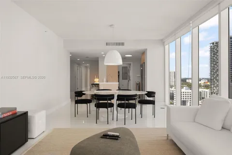 a large white room with kitchen island furniture and a chandelier