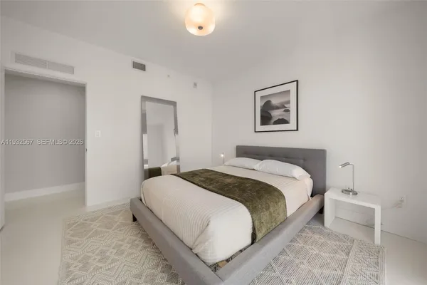 a bedroom with a bed and painting on the wall