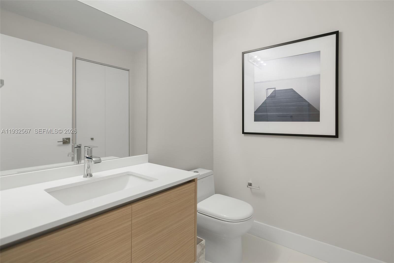 600 Northeast 27th Street, Unit 2401 Miami, FL 33137 - Photo 42 of 52 a bathroom with a toilet a sink and mirror