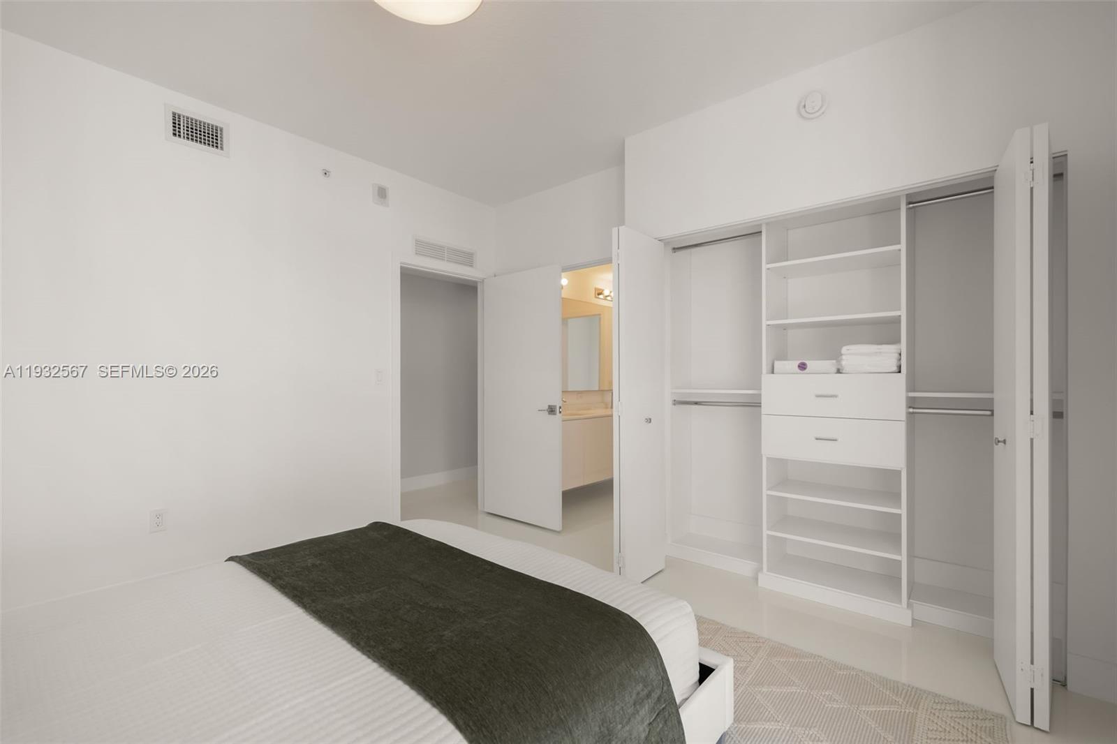 600 Northeast 27th Street, Unit 2401 Miami, FL 33137 - Photo 44 of 52 a bedroom with a bed and a walk in closet