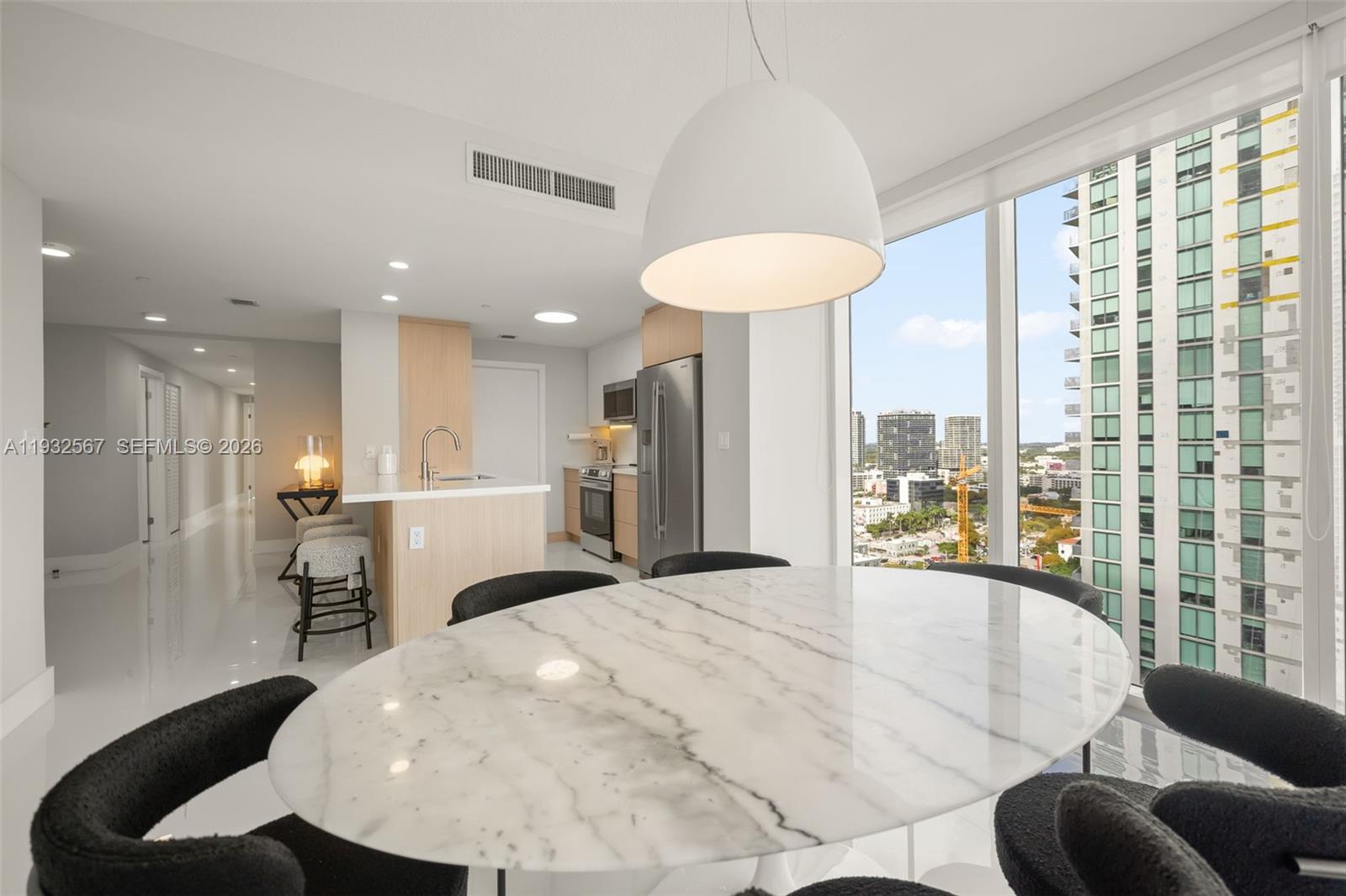 600 Northeast 27th Street, Unit 2401 Miami, FL 33137 - Photo 6 of 52 a large white room with kitchen island furniture and a chandelier