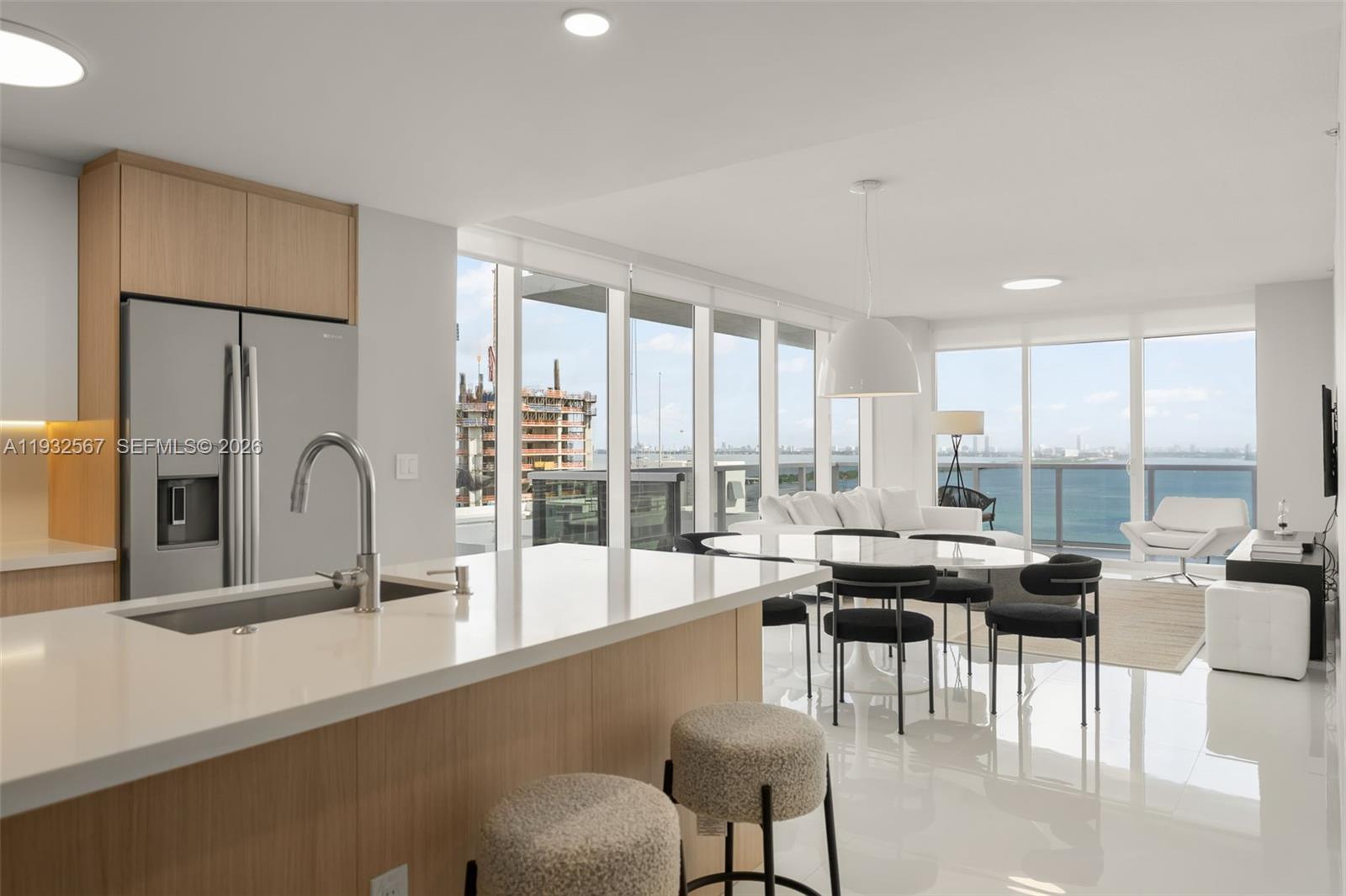 600 Northeast 27th Street, Unit 2401 Miami, FL 33137 - Photo 10 of 52 a dining hall with stainless steel appliances granite countertop a stove a refrigerator a dining table and chairs with wooden floor
