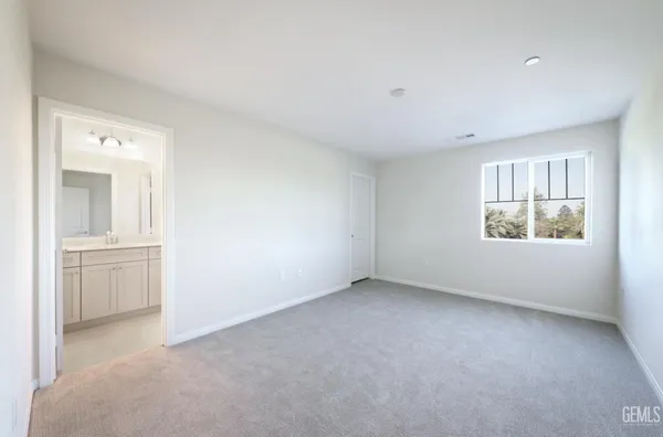 a large kitchen with stainless steel appliances granite countertop a large stove top oven a sink dishwasher a dining table and chairs with wooden floor