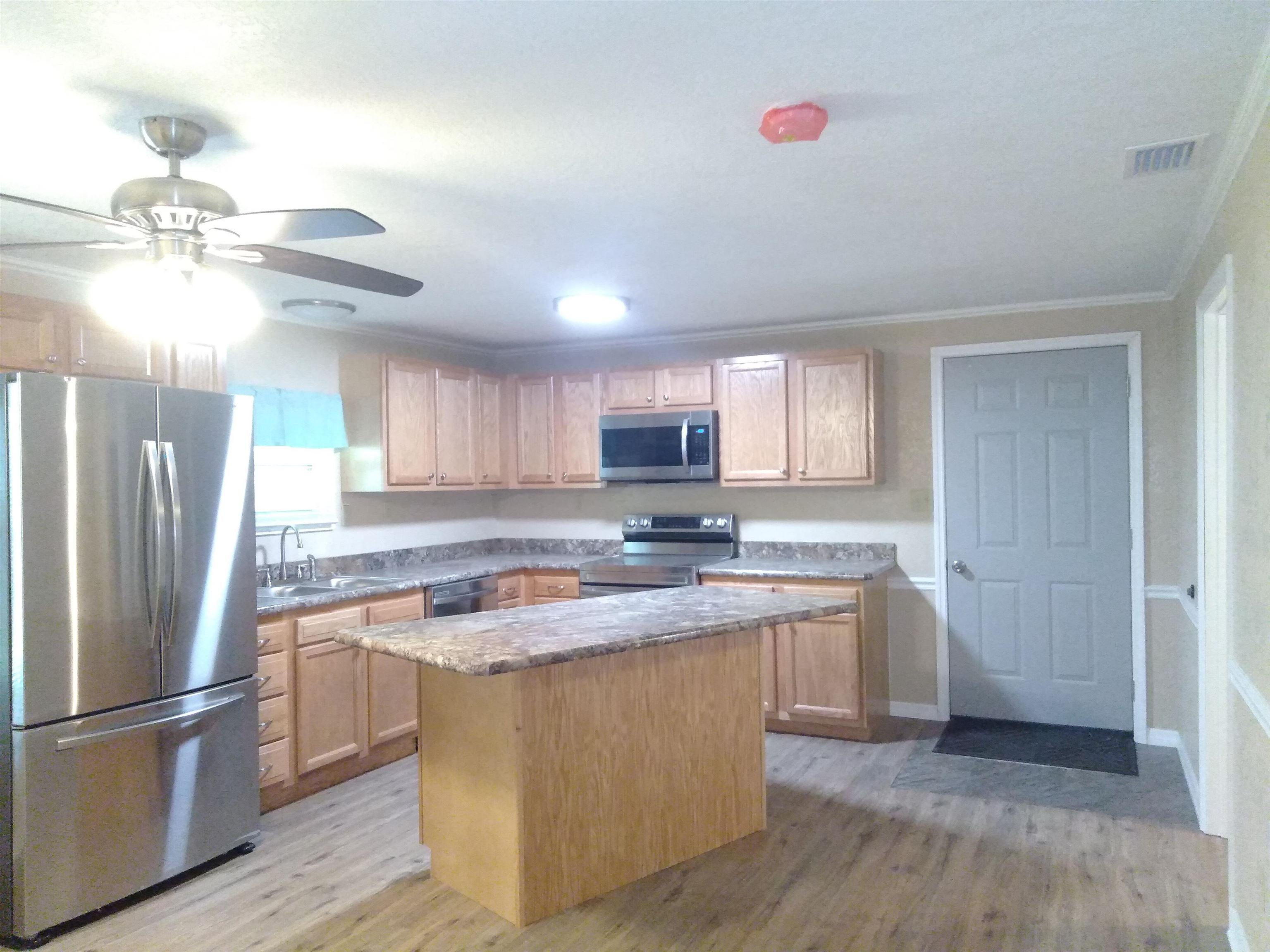 106 Putnam Loop Road Melrose, FL 32666 - Photo 9 of 28 a kitchen with stainless steel appliances granite countertop a sink and a refrigerator