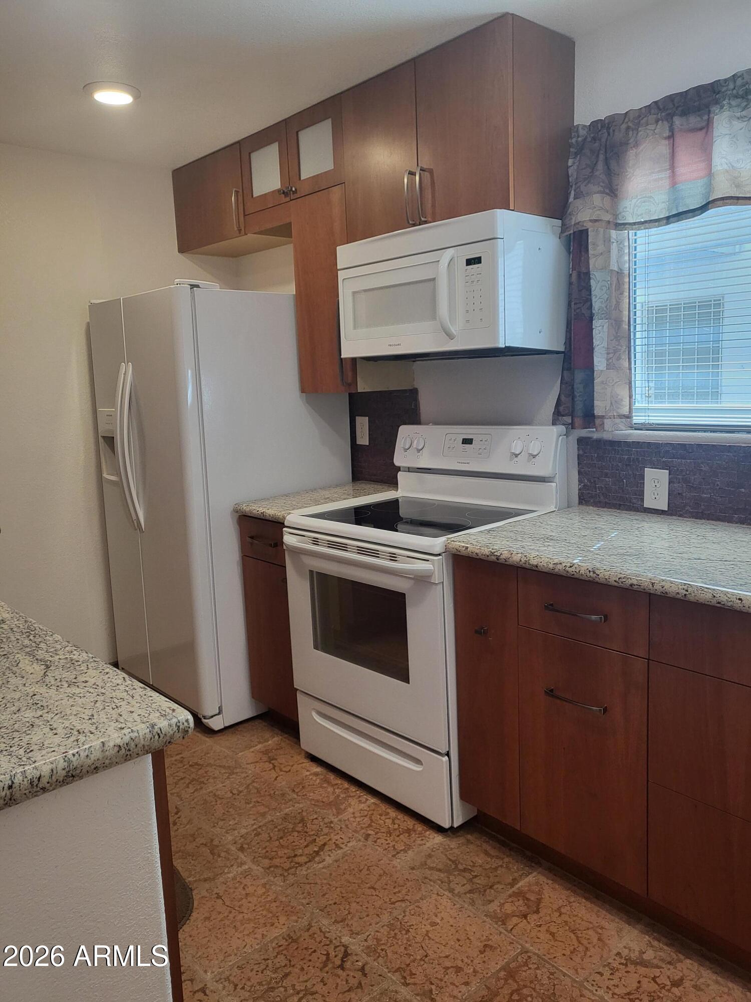 825 North Hayden Road, Unit C108 Scottsdale, AZ 85257 - Photo 16 of 34 a kitchen with granite countertop a stove sink and refrigerator