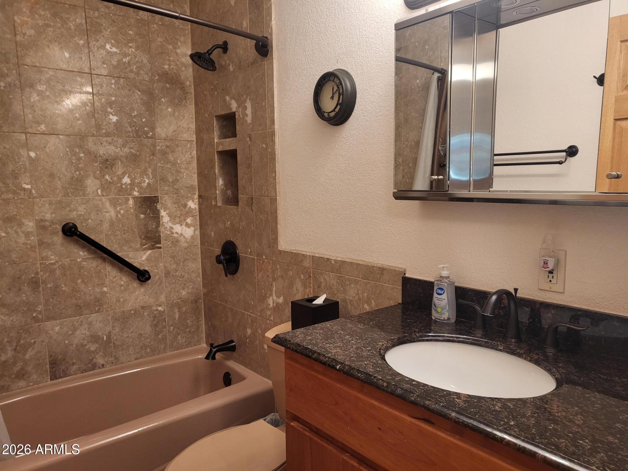 825 North Hayden Road, Unit C108 Scottsdale, AZ 85257 - Photo 17 of 34 a bathroom with a granite countertop sink a toilet and a mirror