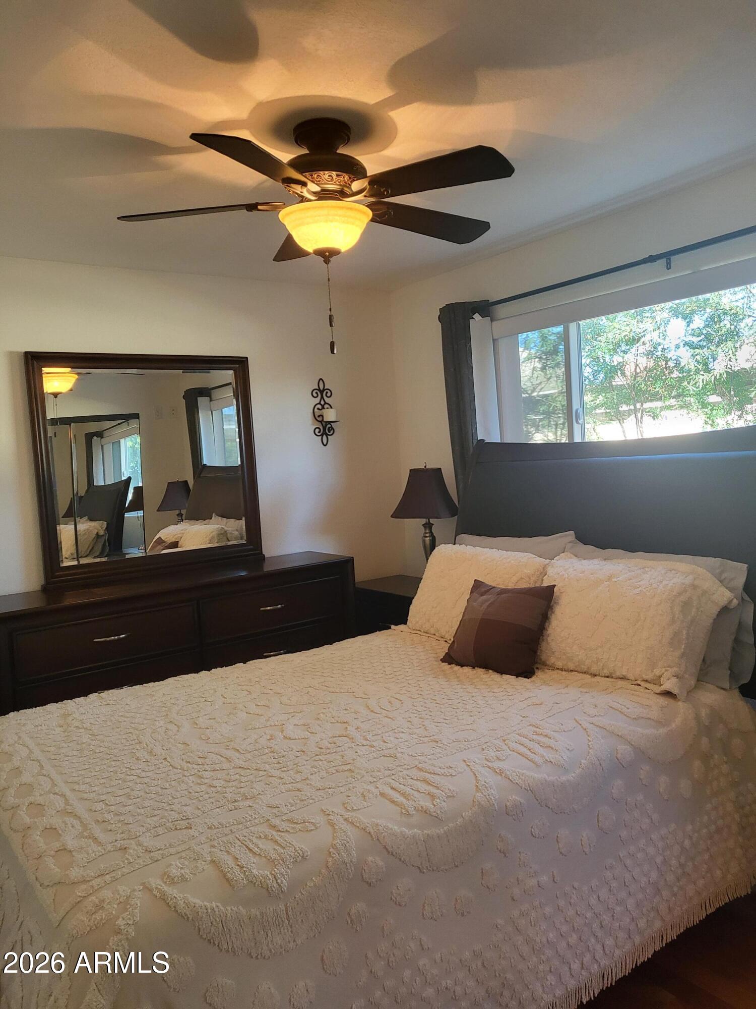 825 North Hayden Road, Unit C108 Scottsdale, AZ 85257 - Photo 20 of 34 a bedroom with a bed and ceiling fan
