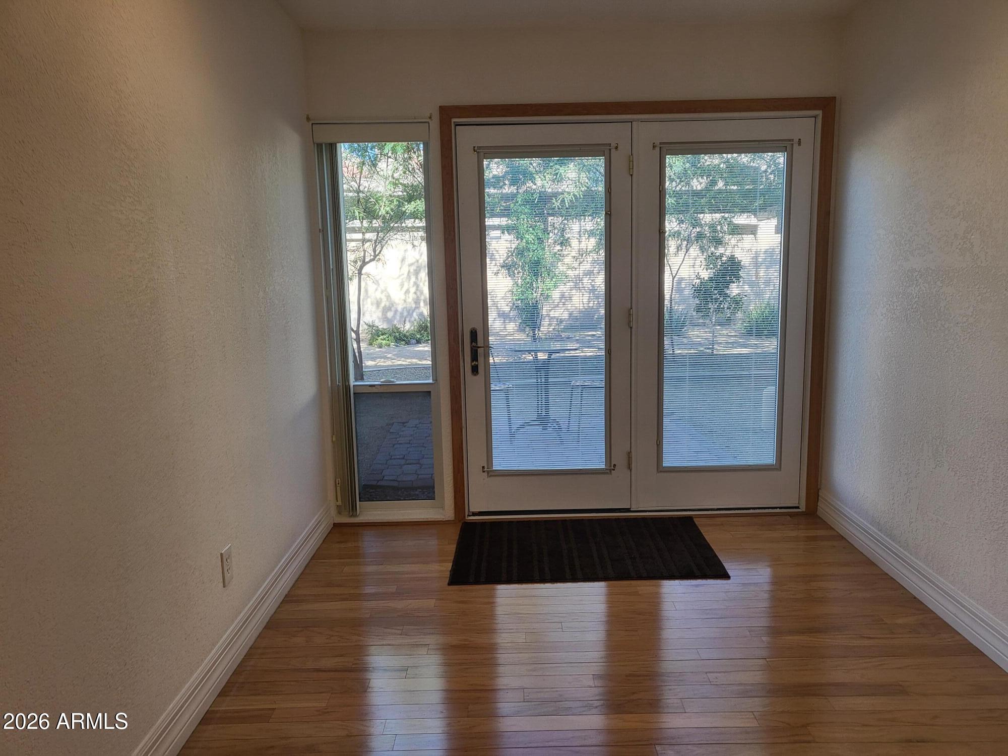 825 North Hayden Road, Unit C108 Scottsdale, AZ 85257 - Photo 8 of 34 a view of an empty room with wooden floor and a window