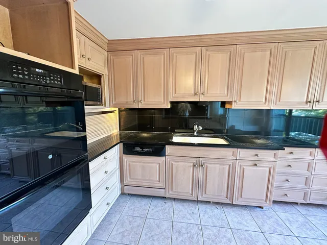 a kitchen with granite countertop a sink a stove and cabinets