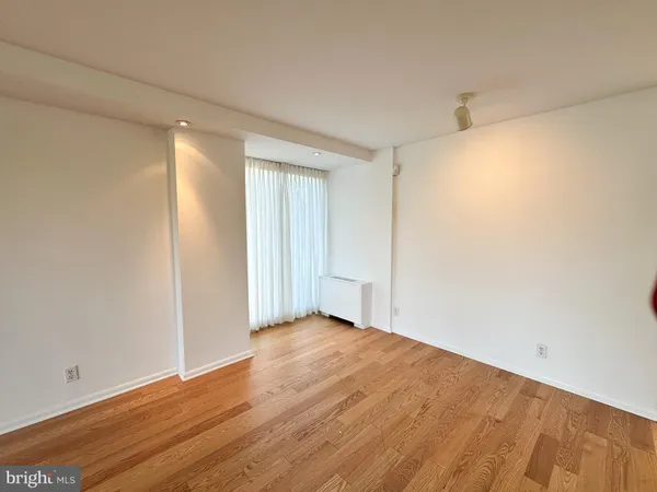 a view of an empty room with wooden floor