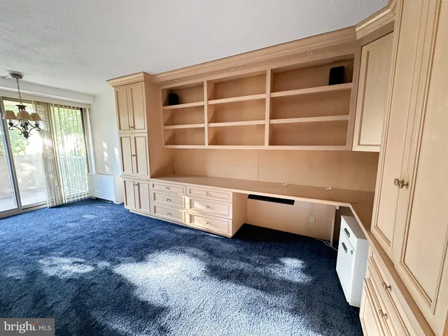 an empty room with cabinet and mirrors