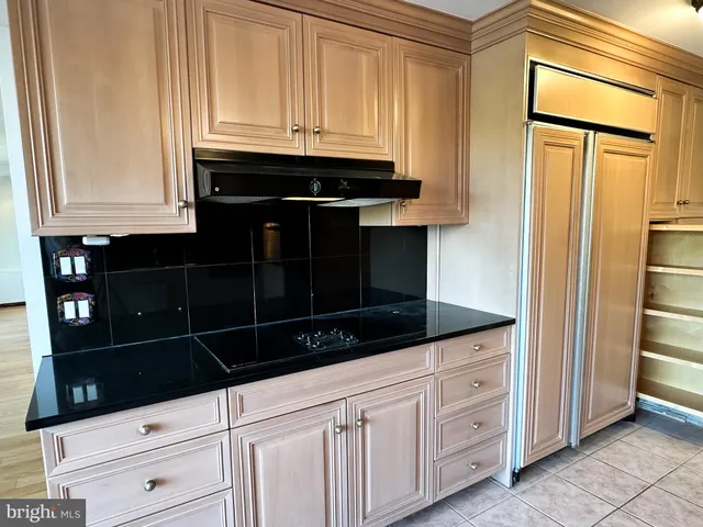 a kitchen with white cabinets and black appliances