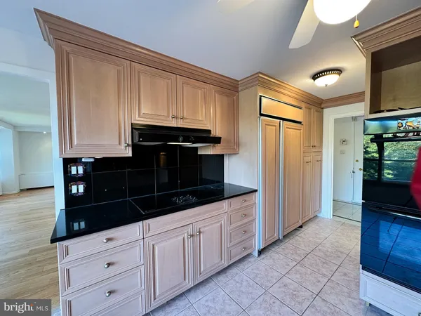 a kitchen with white cabinets and black appliances