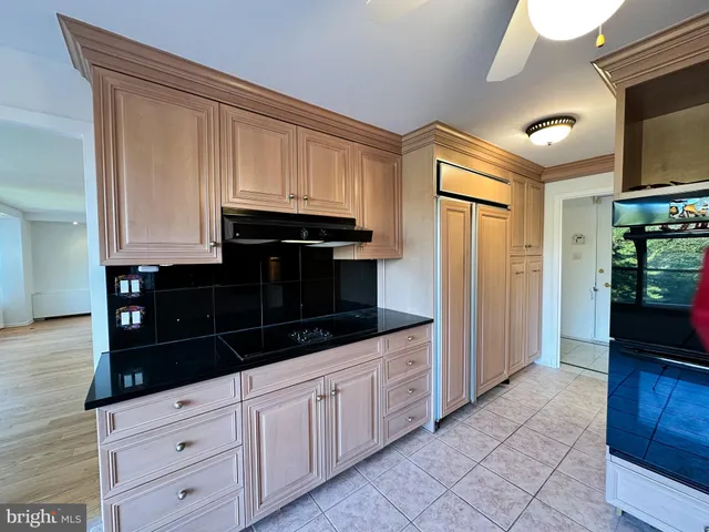 a kitchen with white cabinets and black appliances