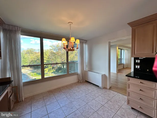 a view of an empty room with window and cabinet