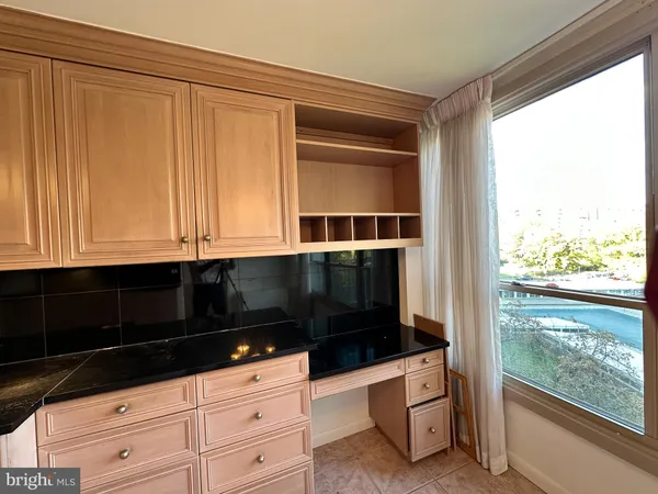 a kitchen with granite countertop white cabinets and black appliances