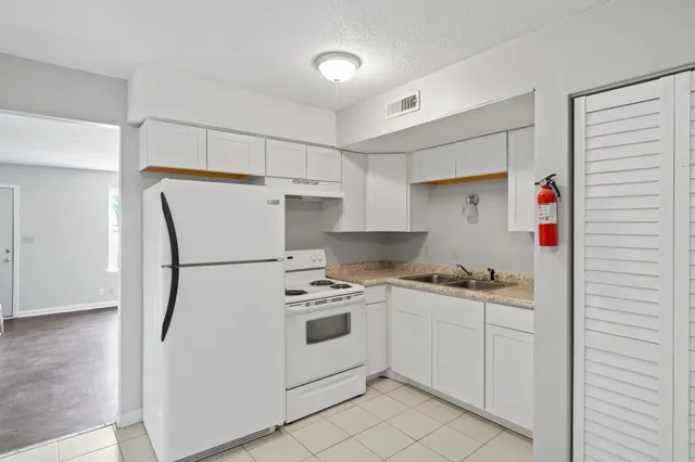 a kitchen with a stove a refrigerator and a sink