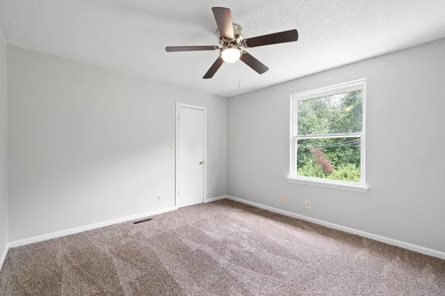 a view of room with ceiling fan and window