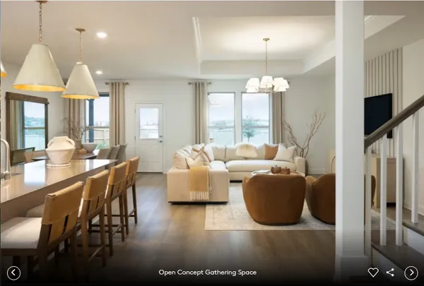a living room with furniture a large window and wooden floor