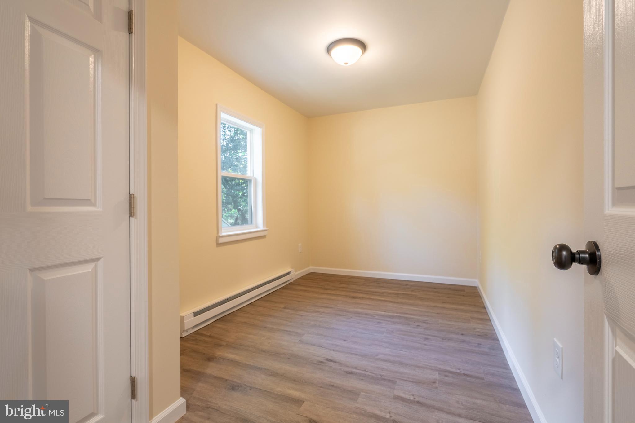 201 Hill Church Road Bechtelsville, PA 19505 - Photo 12 of 28 an empty room with wooden floor and windows