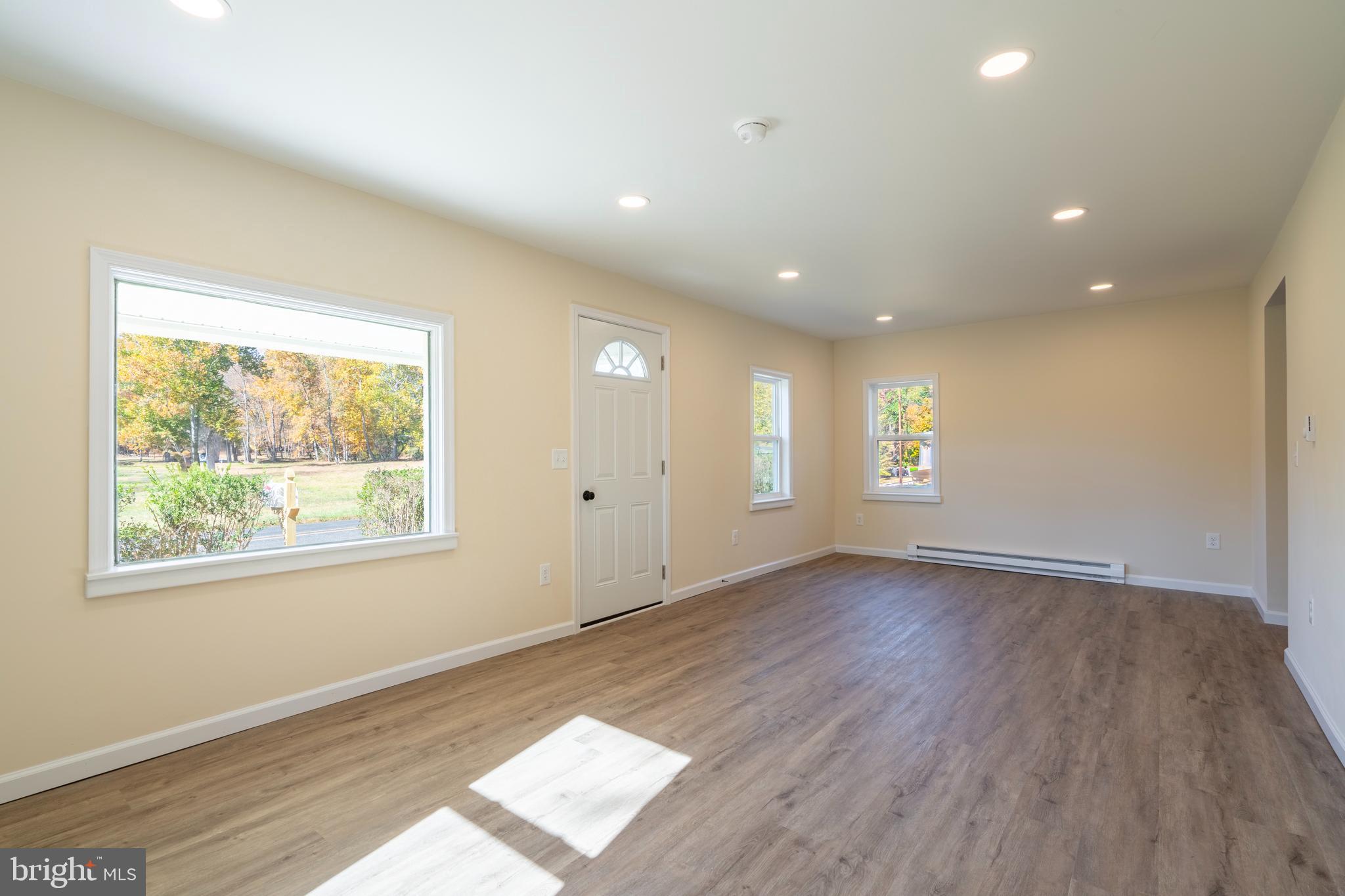 201 Hill Church Road Bechtelsville, PA 19505 - Photo 5 of 28 a view of an empty room with wooden floor and a window