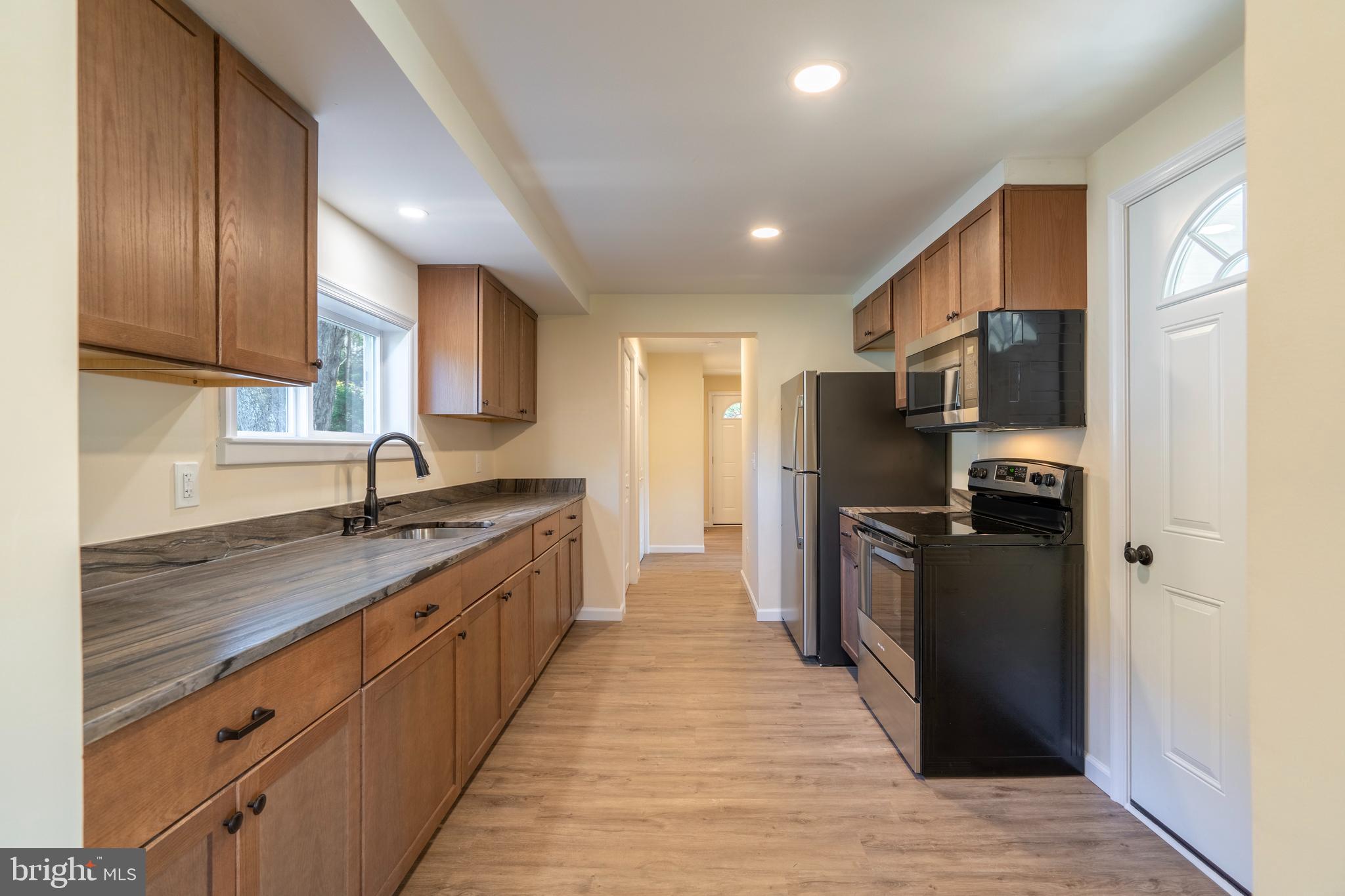 201 Hill Church Road Bechtelsville, PA 19505 - Photo 6 of 28 a large kitchen with stainless steel appliances granite countertop a refrigerator a sink dishwasher a stove with wooden cabinets and a granite counter top